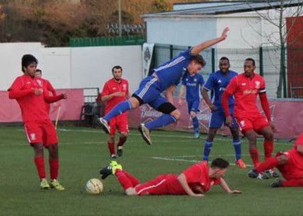 Mark Jones (blue) of Peterborough Sports in action at Wembley FC.