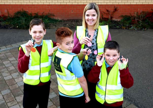 Deputy headteacher Sarah Moss and children from Hampton Hargate Primary School show off their reflectors donated by CALA Homes.
Picture: Paul Marriott Photography