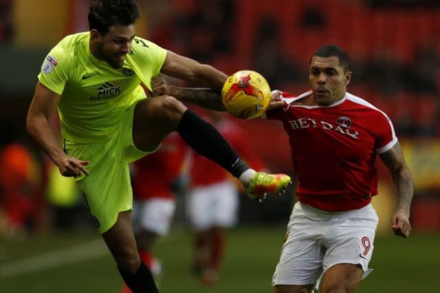 Posh centre-back Ryan Tafazolli tangles with Charlton's Josh Magennis.