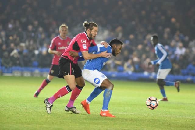 Posh striker Shaquile Coulthirst holds off Notts County's Alan Smith.