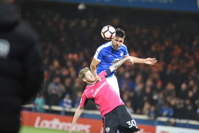 Posh defender Andrew Hughes beats County's Jon Stead in the air. Photo: David Lowndes.