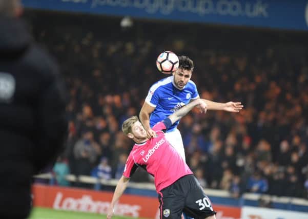 Posh defender Andrew Hughes beats County's Jon Stead in the air. Photo: David Lowndes.