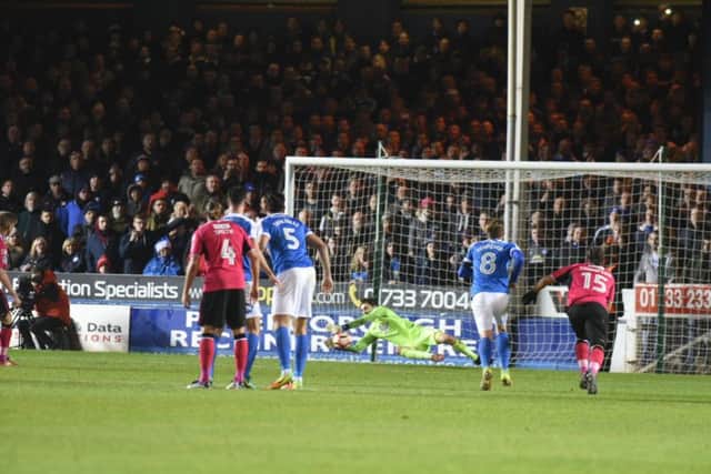 Posh goalkeeper Luke McGee saves a penalty in the FA Cup win over Notts County.