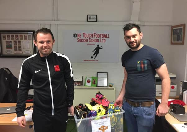 Glenn Vaughan (left) of One Touch and Tom Berridge from Birchwood Special School with some  ot the boots donated.