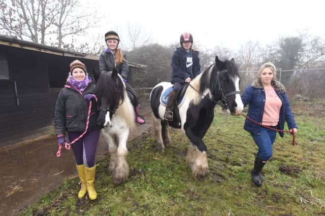Alison Greeton and  Lucy Filippone with riders Layla Sandalls and Temeka Evans with horses  Apple and Alfie at the riding stables at Stanground where  there is a proposed development on the site EMN-161228-144701009