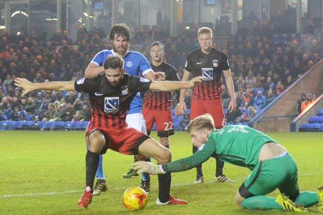 Coventry goalkeeper Lee Burge dives on the ball before Michael Bostwick can pounce. Photo: David Lowndes.