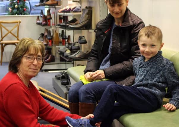 Rosemary Gray helps ensure youngster Callum Elms gets the right footwear.