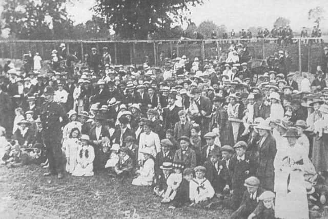 Crowds gather to greet the plane and pilot W H Ewen