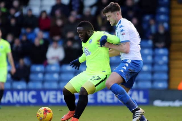 Junior Morias of Peterborough United holds off Bury's Cameron Burgess. Picture: Joe Dent