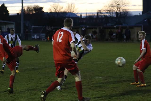 James Hill Seekings (stripes) scores Peterborough Northern Star's consolation goal against Oadby. Photo: Tim Gates.