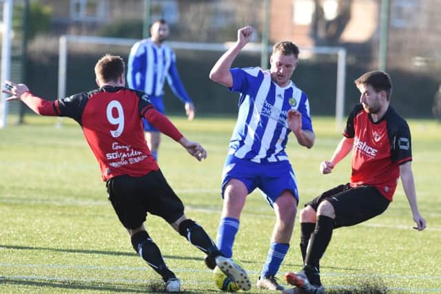 Peterborough Sports Reserve team striker Karl Gibbs is the meat in a Netherton United sandwich. Photo: David Lowndes.