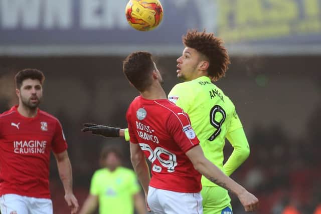 Posh striker Lee Angol in an aerial duel at Swindon. Photo: Joe Dent/theposh.com.