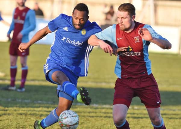 Avelino Vieira (blue) bagged Peterborough Sports 100th goal of the Premier Division season at Oadby.