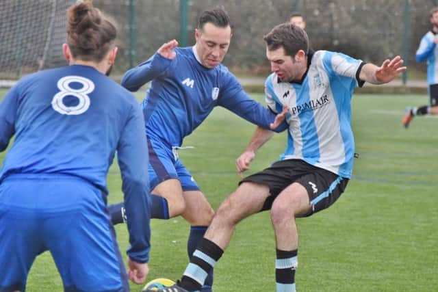 Players from Feeder FC (blue|) and Premiair get stuck in during their Peterborough League Division Four match. Photo: David Lowndes.