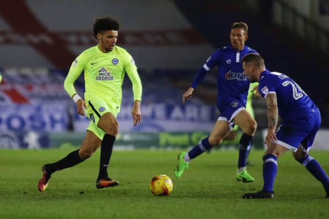 Posh striker Lee Angol runs at Oldham skipper Peter Clarke. Photo: Joe Dent/theposh.com.