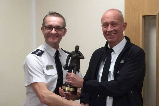 Harry Edge being presented with a figurine from Area Commander Maurice Moore