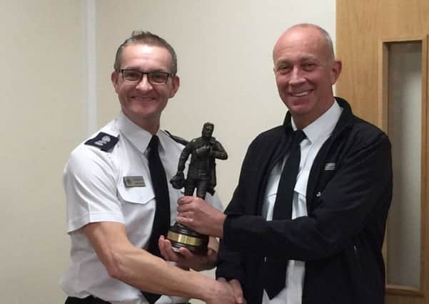 Harry Edge being presented with a figurine from Area Commander Maurice Moore