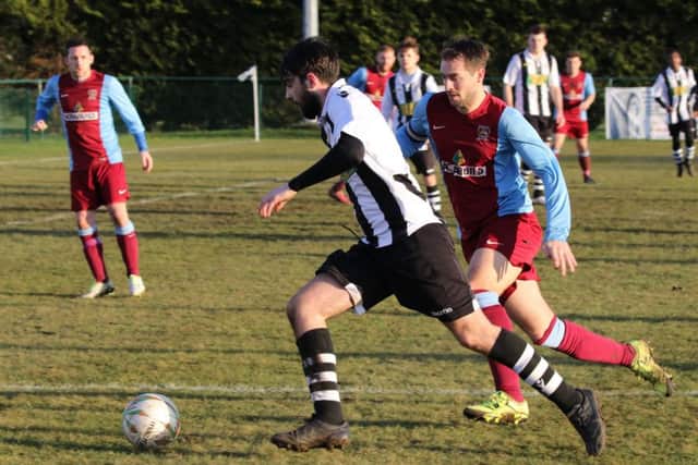 Connor Murphy (stripes) breaks forward for Peterborough Northern Star against Deeping Rangers. Photo: Tim Gates.