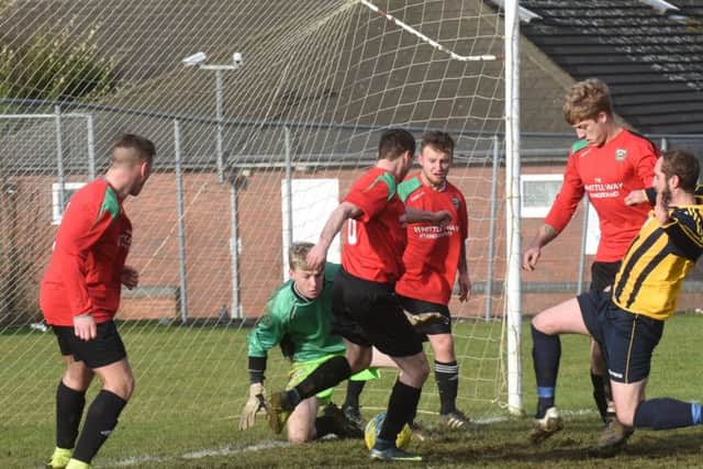 Goalmouth action as Bretton North End (stripes) beat AFC Stanground Sports A 6-0. Photo: David Lowndes.