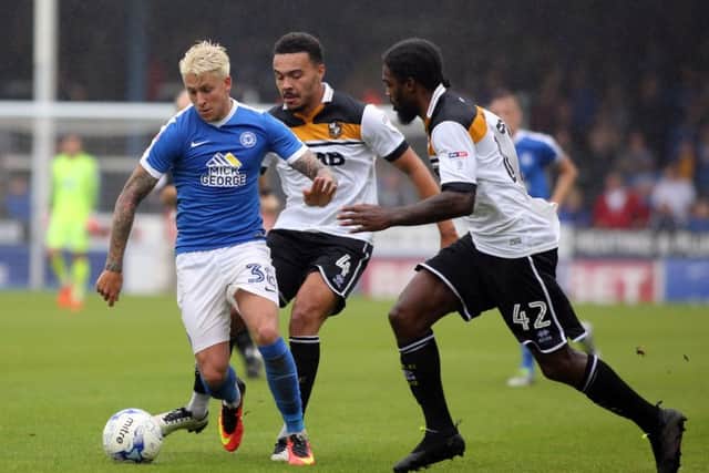 Port Vale's Anthony Grant (right) moves into to challenge Posh midfielder George Moncur.