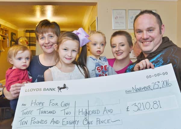 Kelly  Stanier with Mia  Stanier (1), Ella  Stanier (3), Cody  Stanier (3), Yazmin Hills (14) who has hair cut and James  Stanier. Cheque pres to Stanier family from Yazmin following her head shave. EMN-170117-181155009