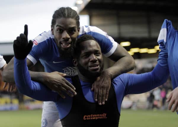 An emotional Junior Morias (kneeling) celebrates the first Football League goal of his career at Port Vale with Anthony Grant. Photo: Joe Dent/theposh.com.