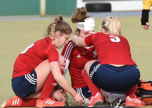 Lucy Dakin of City of Peterborough Ladies  has a head injury tended by team-mates Robyn Gribble and Emma Faux during the 10-1 win against Colchester. Photo: David Lowndes.