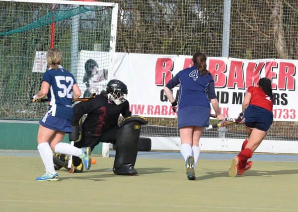 Tierney Augustine (red) scores one of her two goals for City of Peterborough Ladies against Colchester. Photo: David Lowndes.