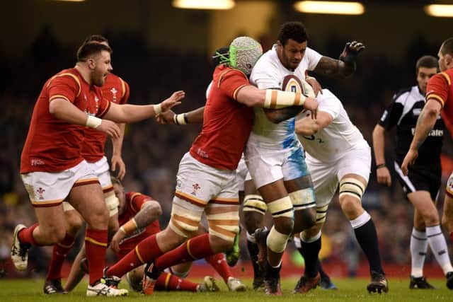 England's Courtney Lawes is tackled by Jake Bell of Wales.