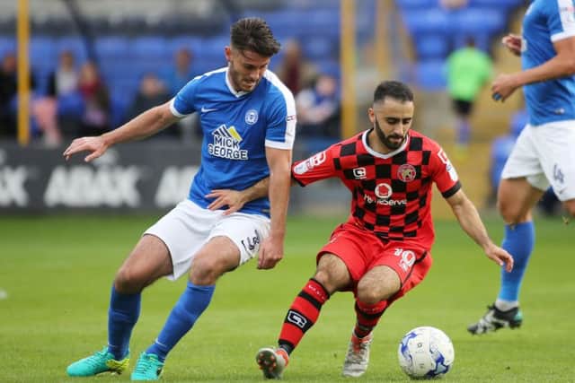Andrew Hughes (Posh) and Erhun Oztumer (Walsall) competing earlier this season.