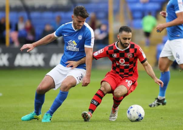Andrew Hughes (Posh) and Erhun Oztumer (Walsall) competing earlier this season.