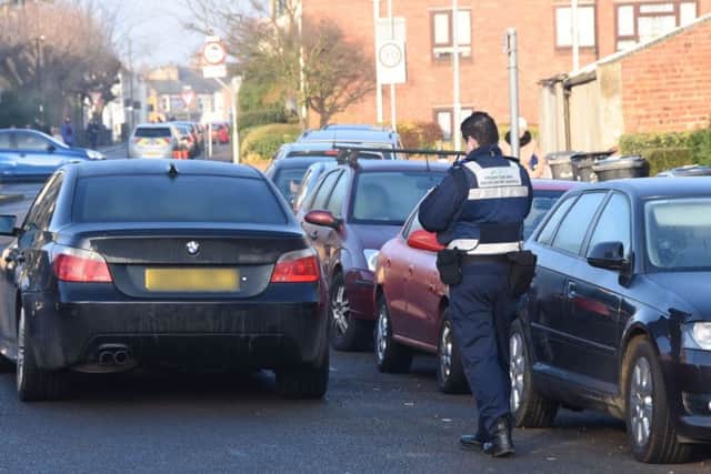 A car parked in the middle of the road outside Queens Drive Infant School