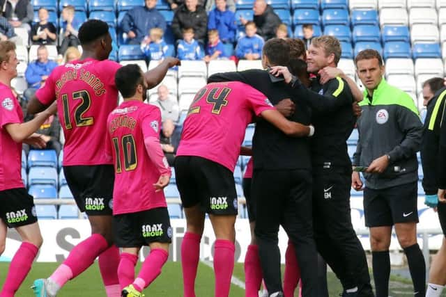 Posh manager Grant McCann (right) enjoys a celebration at Oldham last season with his players including Erhun Oztumer (10).
