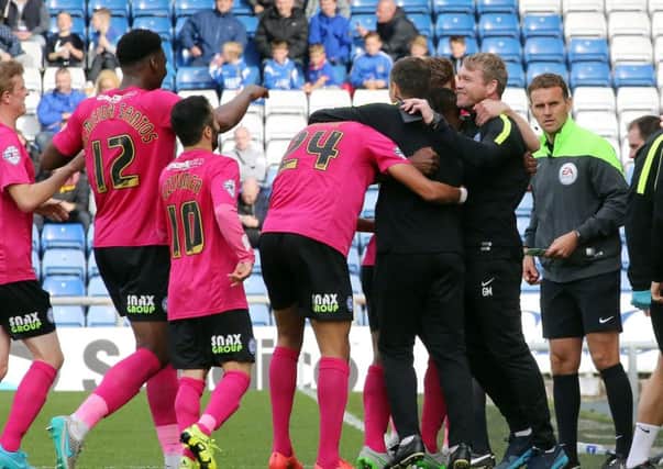 Posh manager Grant McCann (right) enjoys a celebration at Oldham last season with his players including Erhun Oztumer (10).