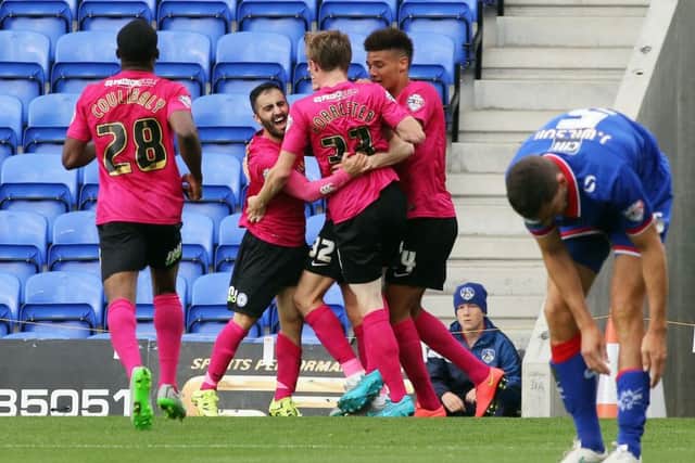 Erhin Oztumer (left of bunch) celebrates a goal for Posh at Oldham last season.