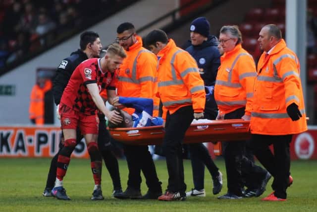 Posh midfielder Gwion Edwards is stretchered off at Walsall.