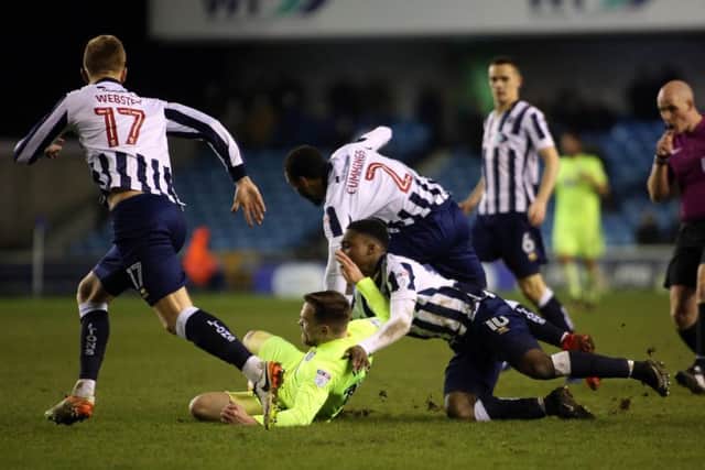 Posh forward Paul Taylor is bundled over at Millwall. Photo: Joe Dent/theposh.com.