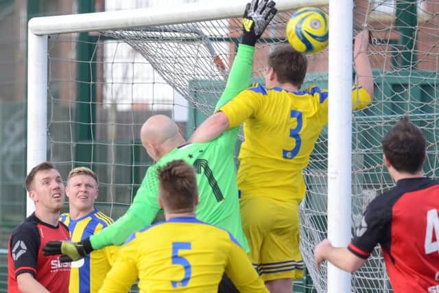 Moulton Harrox (yellow) defending their six-yard box against Netherton at the Grange. Photo: David Lowndes.