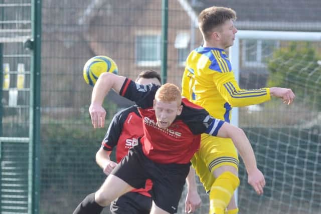 Netherton skipper Herbie Panting (red) challenges for the ball against Moulton Harrox. Photo: David Lowndes.