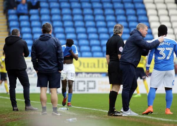 Posh midfielder Leo Da Silva Lopes trudges off the pitch after his red card against Oxford while manager Grant McCann issues instructions to striker Junior Morias. Photo: Joe Dent/theposh.com.