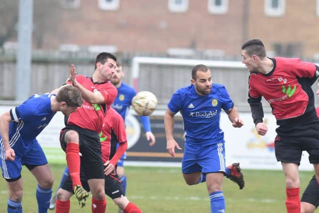 Olly Medwynter (centre, blue) scored for Peterborough Sports at Rothwell Corinthians.