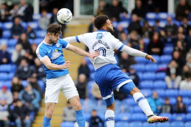 Posh full-back Andrew Hughes beats Oldham's Aaron Holloway in the air. Photo: Joe Dent/theposh.com.