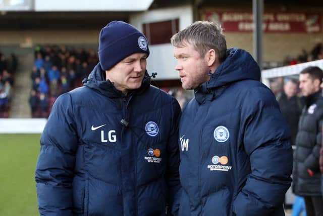 Lee Glover (left) speaks with Posh manager Grant McCann before a game at Scunthorpe.