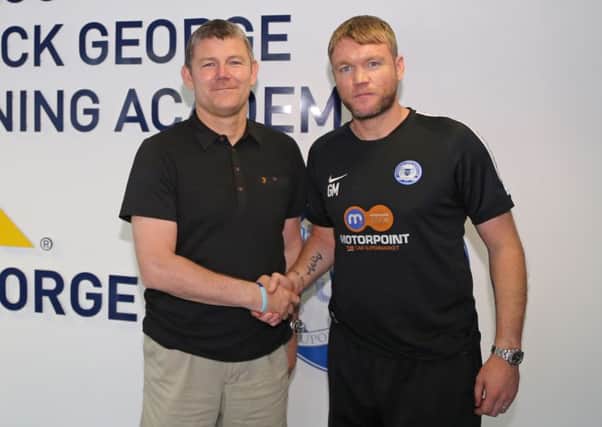 Lee Glover (left) is welcomed to Posh by manager Grant McCann last summer.