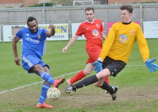Peterborough Sports' striker Avelino Vieira (blue) on the attack against Oadby.