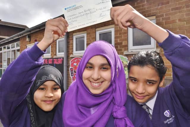 Newark Hill Academy pupil Fatema Damani (11) who raised £142 on her birthday at a bake sale for charity. With her are helpers Haleema Nadeem (left) and Areebar Asif ( right) EMN-170324-174937009