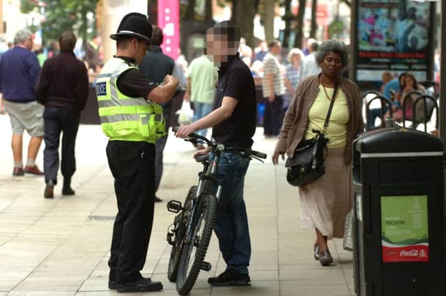 A cyclist is booked by a Police officer for riding along Bridge street during a campaign to reduce the number of cyclists ignoring no cycling signs ENGEMN00120110729165630
