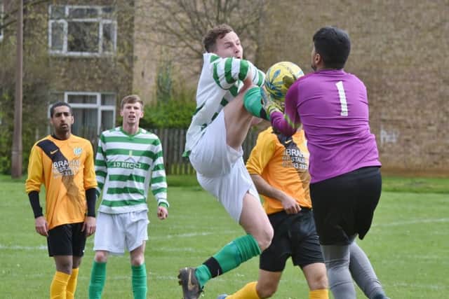 High-kicking action from FC Peterborough's 1-0 win over Eye United (hoops) in Division Three of the Peterborough League. Photo: David Lowndes.