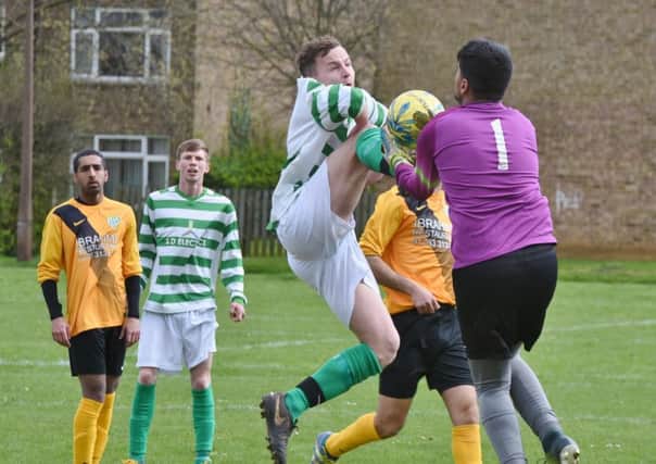 High-kicking action from FC Peterborough's 1-0 win over Eye United (hoops) in Division Three of the Peterborough League. Photo: David Lowndes.