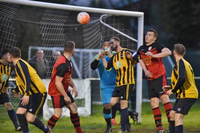 Bretton North End defender David Weston (yellow, centre) is about to defend a Brotherhood Sports corner. Photo: David Lowndes.